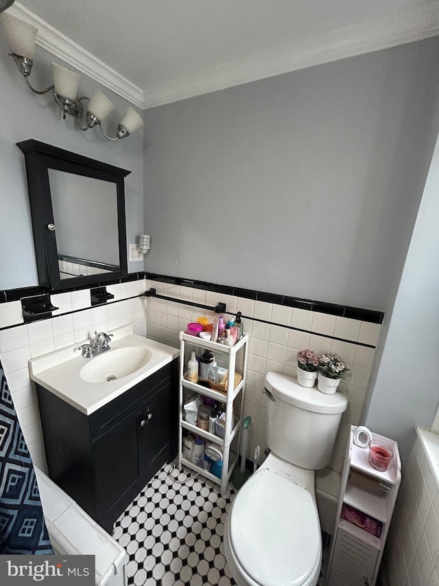 3030 Edgemont St, Philadelphia, PA 19134 - bathroom featuring tile walls, vanity, crown molding, and a wainscoted wall