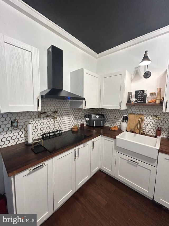 3030 Edgemont St, Philadelphia, PA 19134 - kitchen featuring wall chimney range hood, dark wood-type flooring, wooden counters, decorative backsplash, and white cabinets
