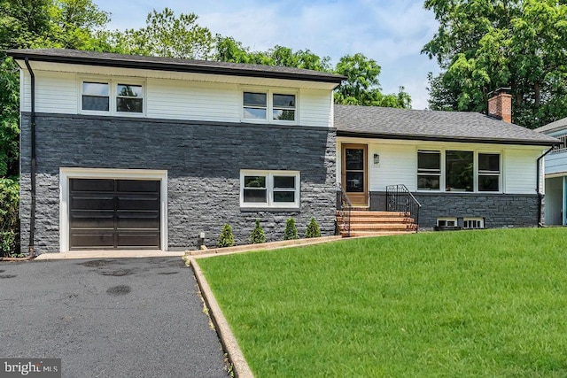 1528 Stuyvesant Ave, Trenton, NJ 08618 - tri-level home with stone siding, a front lawn, a garage, a chimney, and driveway