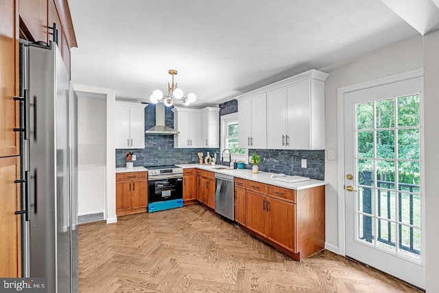 1528 Stuyvesant Ave, Trenton, NJ 08618 - kitchen featuring appliances with stainless steel finishes, wall chimney range hood, light countertops, a chandelier, and backsplash