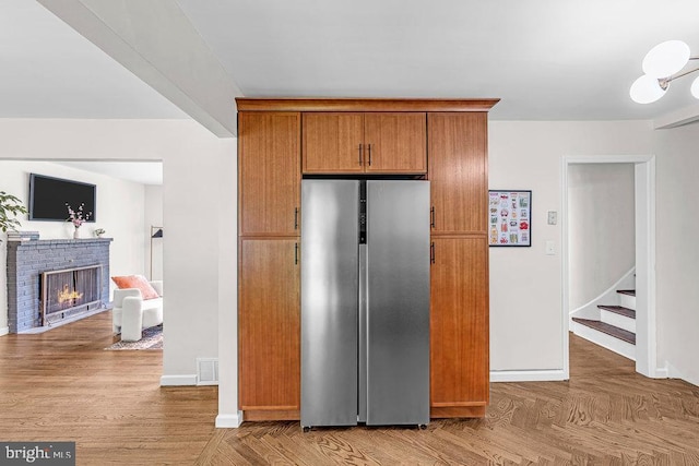 1528 Stuyvesant Ave, Trenton, NJ 08618 - kitchen featuring stainless steel refrigerator, a fireplace, and brown cabinets