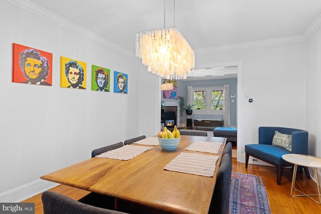 16 E Abington Ave, Philadelphia, PA 19118 - dining space with crown molding, wood-type flooring, a chandelier, and a fireplace