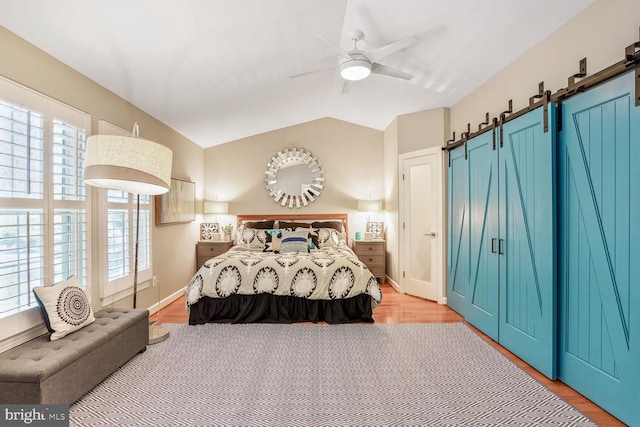 47643 Rhyolite Pl, Sterling, VA 20165 - bedroom with a barn door, light wood-type flooring, lofted ceiling, and ceiling fan