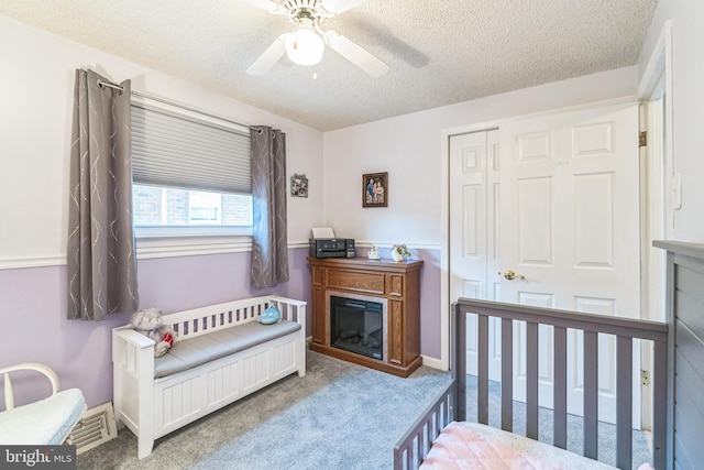 8905 Dewees St, Philadelphia, PA 19152 - carpeted bedroom with a textured ceiling, a closet, ceiling fan, and a glass covered fireplace