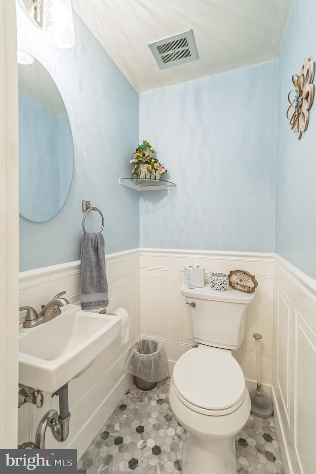 8905 Dewees St, Philadelphia, PA 19152 - half bathroom featuring a decorative wall and a wainscoted wall