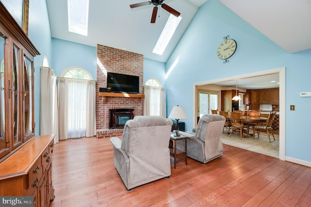 14 Quail Ridge Dr, Reading, PA 19607 - living room with a skylight, high vaulted ceiling, light wood finished floors, a brick fireplace, and a ceiling fan
