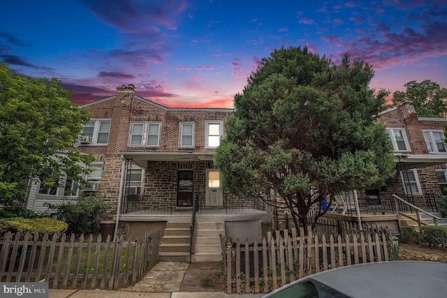 4641 Fernhill Rd, Philadelphia, PA 19144 - townhome / multi-family property featuring a porch, a fenced front yard, brick siding, stairway, and a chimney