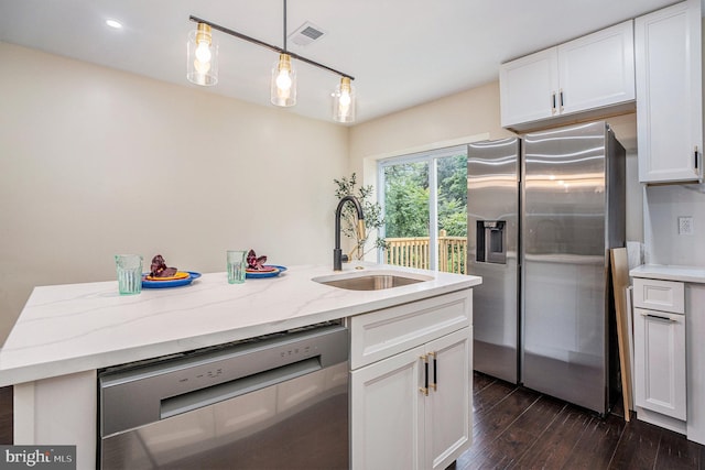 4641 Fernhill Rd, Philadelphia, PA 19144 - kitchen featuring appliances with stainless steel finishes, dark wood-style floors, white cabinetry, hanging light fixtures, and light stone counters