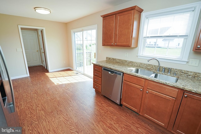 1322 Aspen Dr, Salisbury, MD 21804 - kitchen featuring dishwasher, light wood-style flooring, brown cabinetry, and light stone countertops
