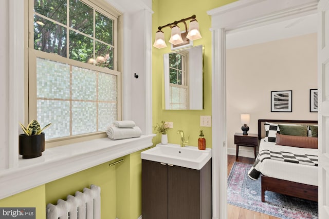 1833 S St NW Unit 2, Washington, DC 20009 - ensuite bathroom featuring radiator heating unit, healthy amount of natural light, vanity, and wood finished floors