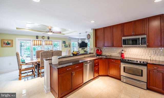 1421 Custom House Sq, Bensalem, PA 19020 - kitchen with appliances with stainless steel finishes, a ceiling fan, a peninsula, wainscoting, and dark stone countertops