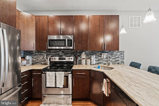 2115 Carpenter St Unit 1, Philadelphia, PA 19146 - kitchen featuring stainless steel appliances, light stone countertops, backsplash, and decorative light fixtures