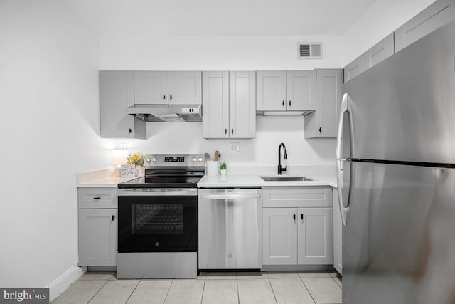 5500 Holmes Run Pkwy Unit 1103, Alexandria, VA 22304 - kitchen with appliances with stainless steel finishes, under cabinet range hood, light countertops, light tile patterned flooring, and gray cabinetry