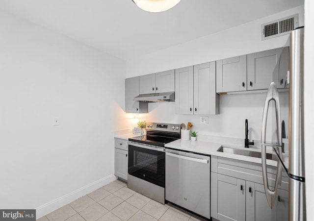 5500 Holmes Run Pkwy Unit 1103, Alexandria, VA 22304 - kitchen with appliances with stainless steel finishes, under cabinet range hood, light countertops, gray cabinetry, and light tile patterned floors