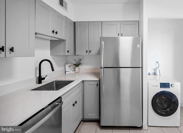 5500 Holmes Run Pkwy Unit 1103, Alexandria, VA 22304 - kitchen featuring stainless steel appliances, washer / clothes dryer, gray cabinetry, light tile patterned floors, and light stone counters