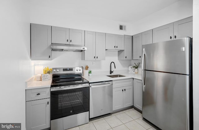 5500 Holmes Run Pkwy Unit 1103, Alexandria, VA 22304 - kitchen with appliances with stainless steel finishes, under cabinet range hood, gray cabinets, light countertops, and light tile patterned floors