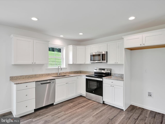 564 Monocacy Trl, Spring Grove, PA 17362 - kitchen featuring appliances with stainless steel finishes, light wood finished floors, white cabinetry, light stone counters, and recessed lighting