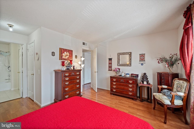 119 Prosperity Ave SE Unit C, Leesburg, VA 20175 - bedroom featuring wood finished floors, a textured ceiling, and connected bathroom