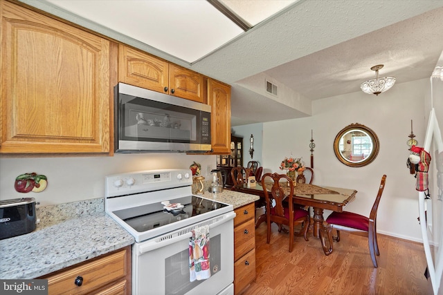 119 Prosperity Ave SE Unit C, Leesburg, VA 20175 - kitchen with white electric range, stainless steel microwave, light wood-style floors, and light stone countertops