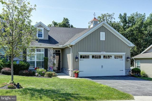 6210 Thornhill Ln, Mechanicsburg, PA 17050 - view of front of house with stone siding, a shingled roof, a garage, a front lawn, and driveway