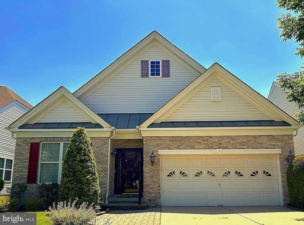 9 Clancy Ct, Marlton, NJ 08053 - view of front of property featuring a standing seam roof, brick siding, an attached garage, concrete driveway, and a metal roof