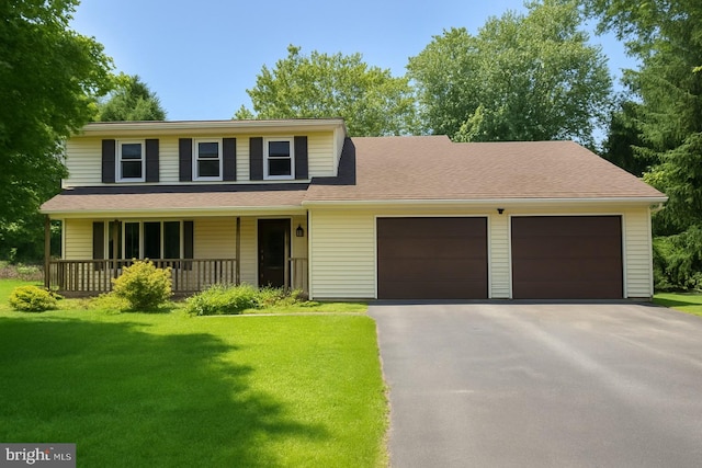 656 Juli Dr, New Freedom, PA 17349 - traditional-style house featuring asphalt driveway, a front lawn, a garage, and a porch
