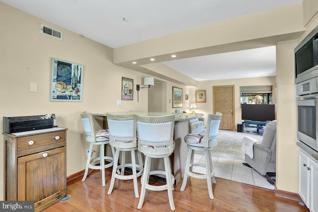 78 Kent Ave, Marlton, NJ 08053 - kitchen with stainless steel appliances, a kitchen bar, recessed lighting, light wood finished floors, and a peninsula
