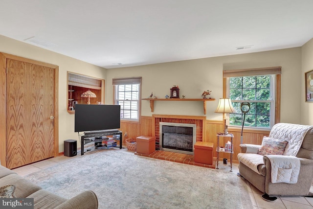 78 Kent Ave, Marlton, NJ 08053 - living room featuring plenty of natural light, a wainscoted wall, a brick fireplace, wood walls, and tile patterned floors