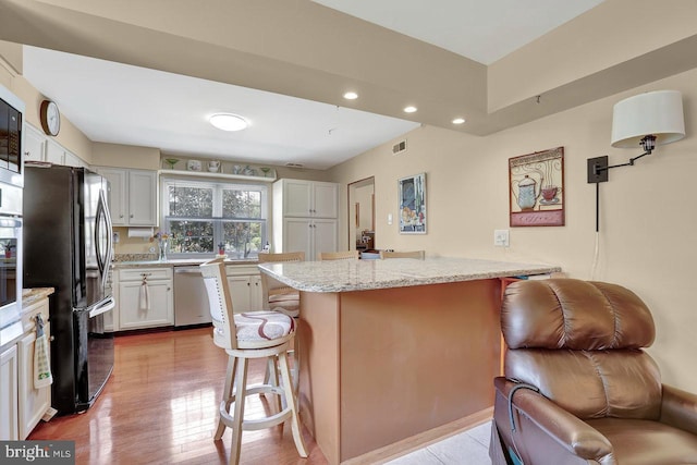 78 Kent Ave, Marlton, NJ 08053 - kitchen featuring appliances with stainless steel finishes, a breakfast bar area, recessed lighting, light stone counters, and light wood-style floors