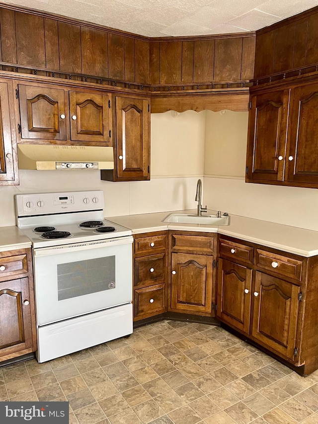 363 New St, Pottstown, PA 19464 - kitchen featuring white range with electric cooktop, under cabinet range hood, light countertops, and stone finish floors