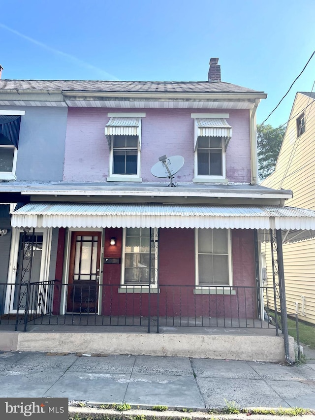 363 New St, Pottstown, PA 19464 - view of front facade featuring covered porch, a chimney, and brick siding