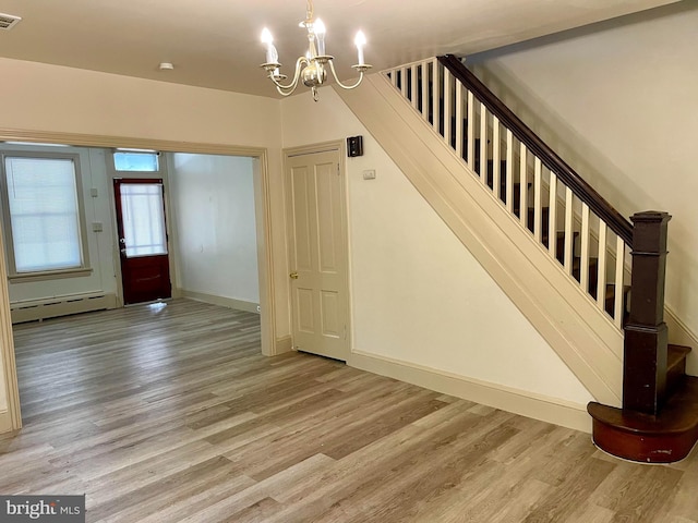 363 New St, Pottstown, PA 19464 - stairway with a baseboard heating unit, wood finished floors, and a chandelier