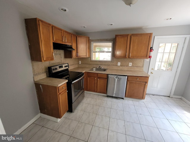 666 Manatawny St, Pottstown, PA 19464 - kitchen featuring stainless steel appliances, under cabinet range hood, tasteful backsplash, and brown cabinetry
