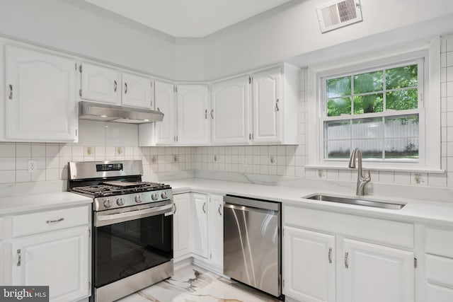 11704 Milbern Dr, Potomac, MD 20854 - kitchen featuring appliances with stainless steel finishes, under cabinet range hood, light marble finish flooring, and white cabinets