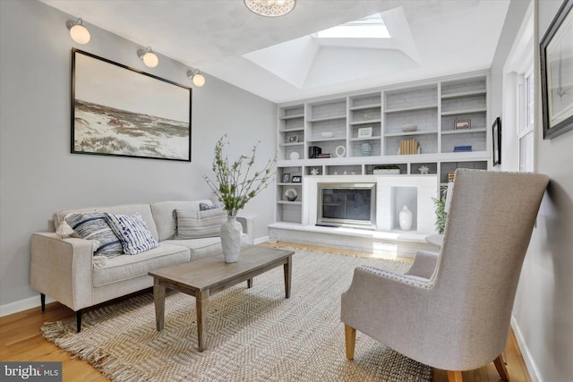 441 Barker Dr, West Chester, PA 19380 - living room with wood finished floors, a skylight, built in shelves, and a glass covered fireplace