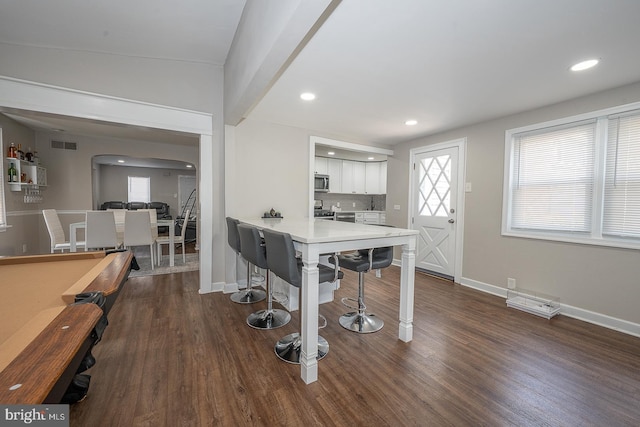 10 Holbrook Rd, Havertown, PA 19083 - kitchen featuring arched walkways, appliances with stainless steel finishes, a kitchen bar, white cabinetry, and dark wood-type flooring