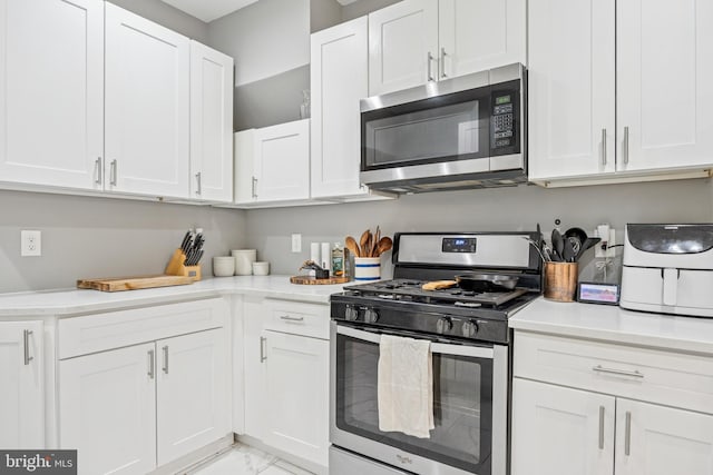 115 E Duval St, Philadelphia, PA 19144 - kitchen with stainless steel appliances, light marble finish flooring, light countertops, and white cabinetry