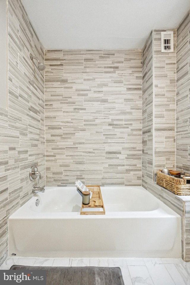 115 E Duval St, Philadelphia, PA 19144 - bathroom with tile walls, a bath, and marble look tiles