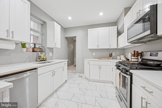 115 E Duval St, Philadelphia, PA 19144 - kitchen featuring appliances with stainless steel finishes, light marble finish flooring, light countertops, white cabinetry, and recessed lighting
