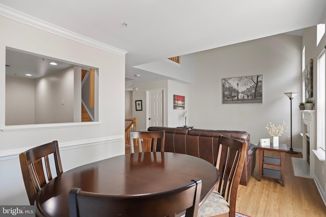 12941 Bridger Dr Unit 1611, Germantown, MD 20874 - dining area featuring light wood-style flooring, a fireplace, ornamental molding, and stairs