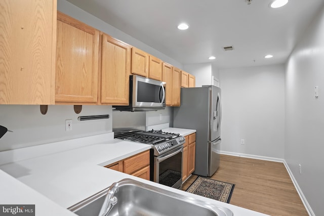 12941 Bridger Dr Unit 1611, Germantown, MD 20874 - kitchen with appliances with stainless steel finishes, wood finished floors, recessed lighting, light countertops, and light brown cabinetry