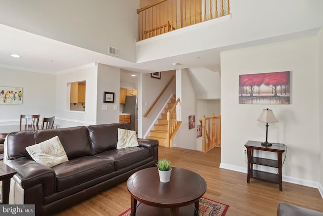12941 Bridger Dr Unit 1611, Germantown, MD 20874 - living room with light wood finished floors, ornamental molding, stairs, recessed lighting, and a high ceiling