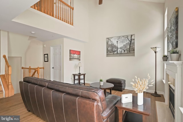 12941 Bridger Dr Unit 1611, Germantown, MD 20874 - living area featuring light wood-style flooring, a fireplace, and a towering ceiling