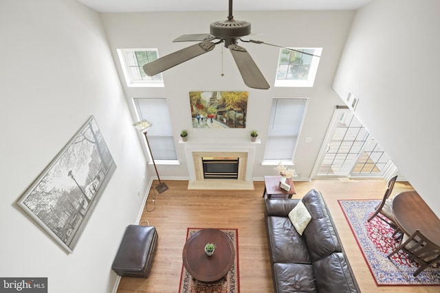 12941 Bridger Dr Unit 1611, Germantown, MD 20874 - living area with a towering ceiling, wood finished floors, a ceiling fan, a glass covered fireplace, and a skylight