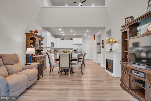 43 Boneset Dr, Gettysburg, PA 17325 - dining area featuring a high ceiling, light wood-style floors, a glass covered fireplace, recessed lighting, and a ceiling fan