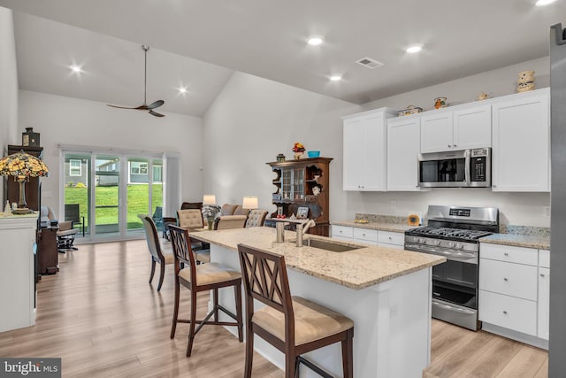 43 Boneset Dr, Gettysburg, PA 17325 - kitchen with appliances with stainless steel finishes, open floor plan, light wood-style floors, white cabinetry, and an island with sink