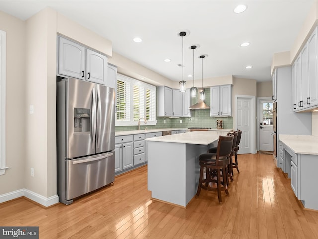 6720 Walter Scott Way, Columbia, MD 21044 - kitchen featuring appliances with stainless steel finishes, wall chimney exhaust hood, gray cabinets, a kitchen island, and light countertops