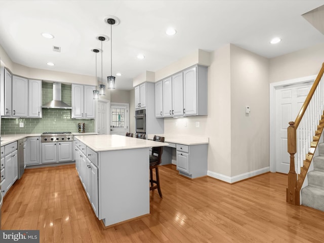 6720 Walter Scott Way, Columbia, MD 21044 - kitchen with gray cabinets, wall chimney exhaust hood, stainless steel appliances, light wood finished floors, and recessed lighting