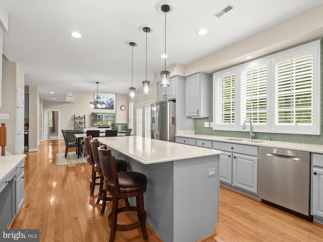 6720 Walter Scott Way, Columbia, MD 21044 - kitchen featuring appliances with stainless steel finishes, gray cabinetry, tasteful backsplash, light countertops, and light wood-type flooring