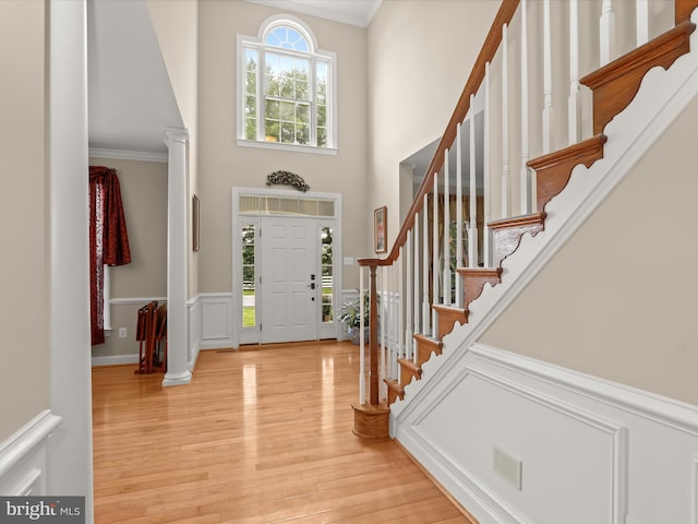 6720 Walter Scott Way, Columbia, MD 21044 - foyer entrance with light wood-type flooring, a towering ceiling, stairway, crown molding, and a wainscoted wall